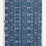 Roll of printed grasscloth with ikat stripe design in blue and cream 