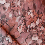 Detail draped fabric in a watercolor textural print in shades of red, gray and black.