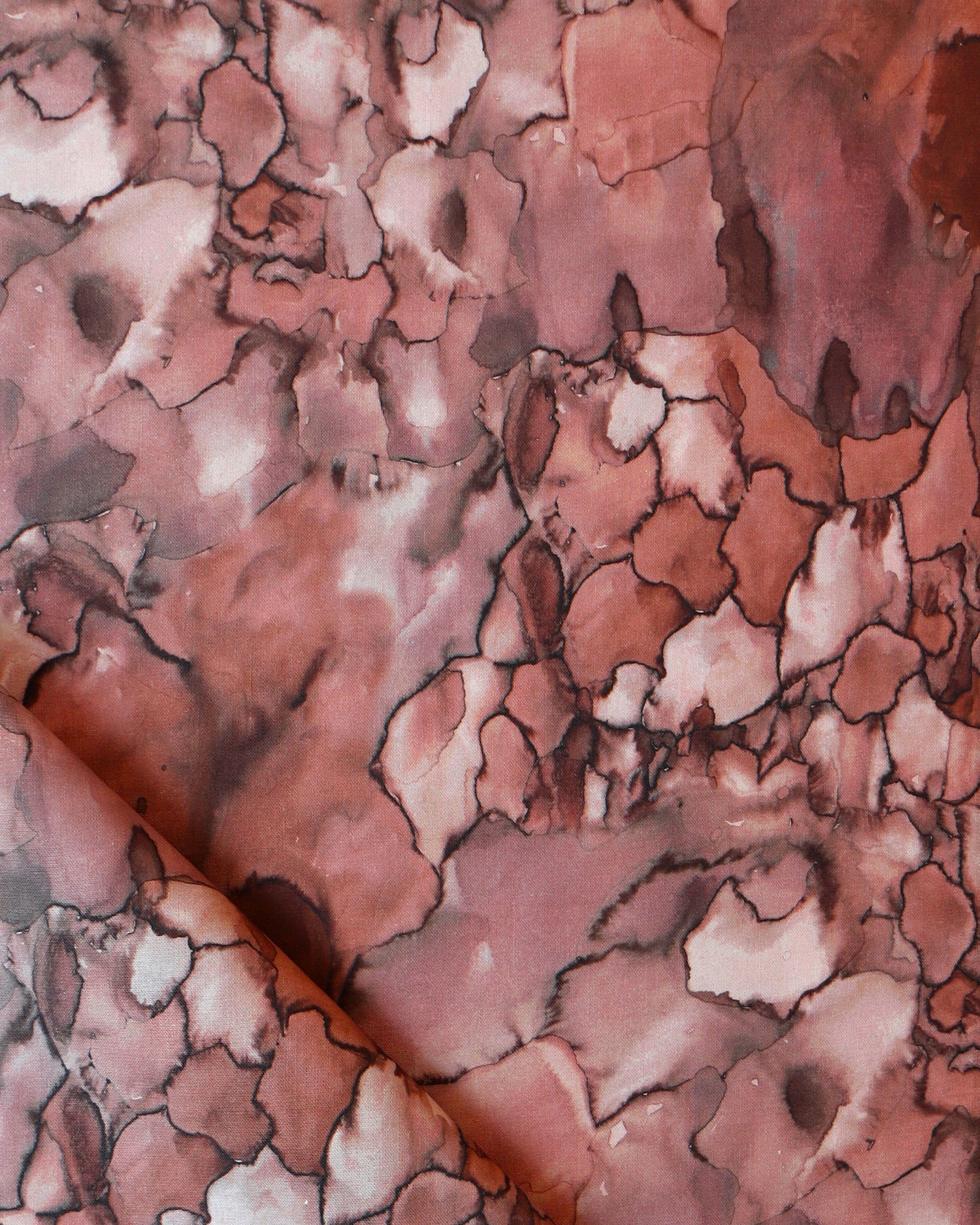 Detail draped fabric in a watercolor textural print in shades of red, gray and black.
