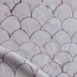 Detail of draped fabric in a watercolor linear scallop pattern in purple on a lilac field. 