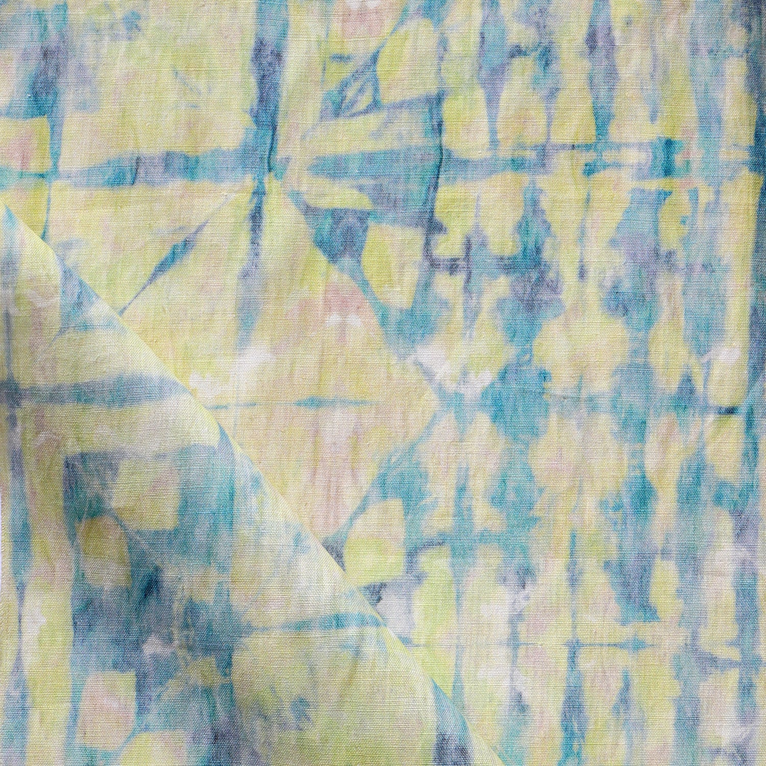 Detail of draped fabric in a watercolor dyed grid print in mottled yellow, blue and white.