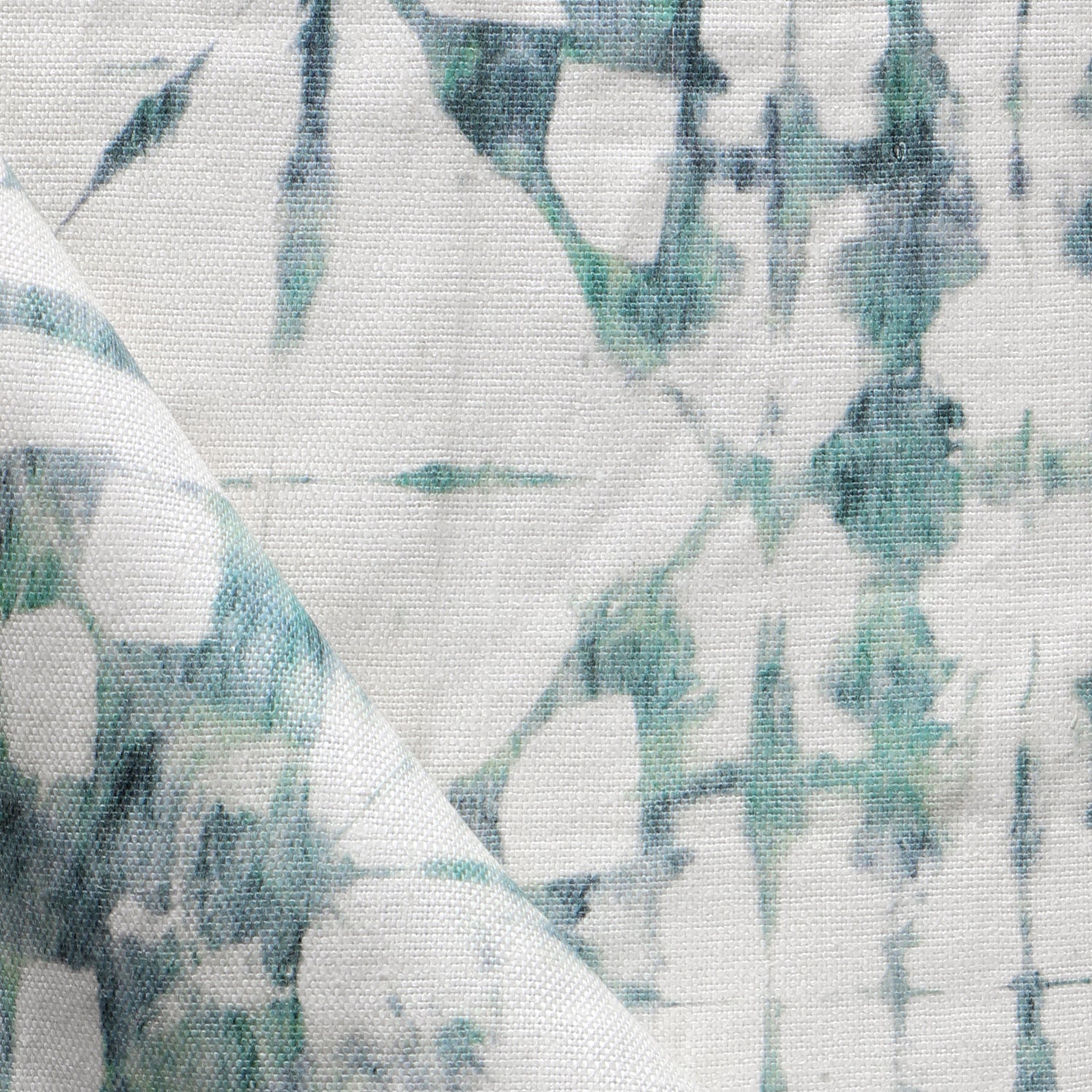 Detail of draped fabric in a watercolor dyed grid print in mottled white and green.