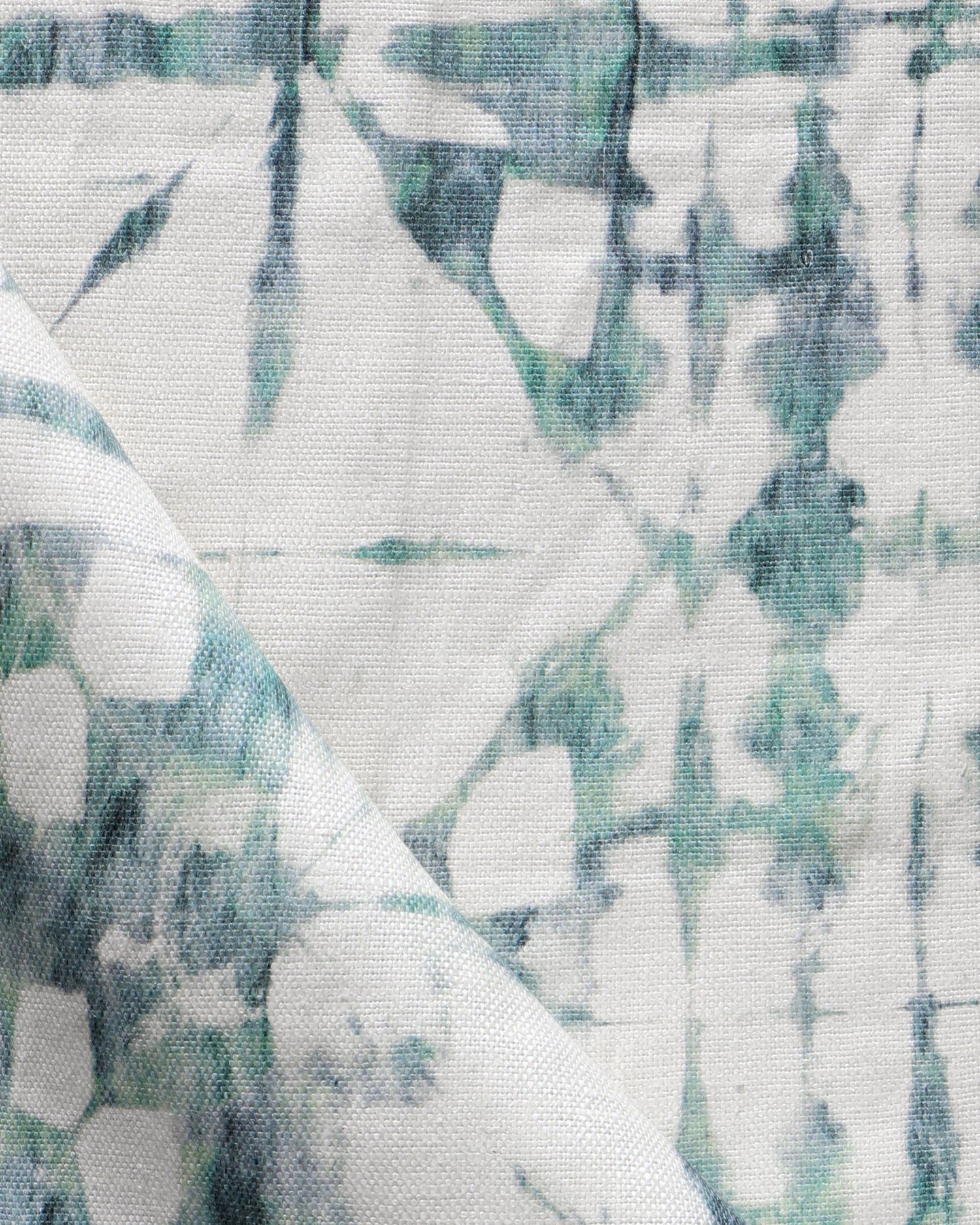 Detail of draped fabric in a watercolor dyed grid print in mottled white and green.