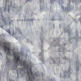 Detail of draped fabric in a watercolor dyed grid print in mottled shades of purple