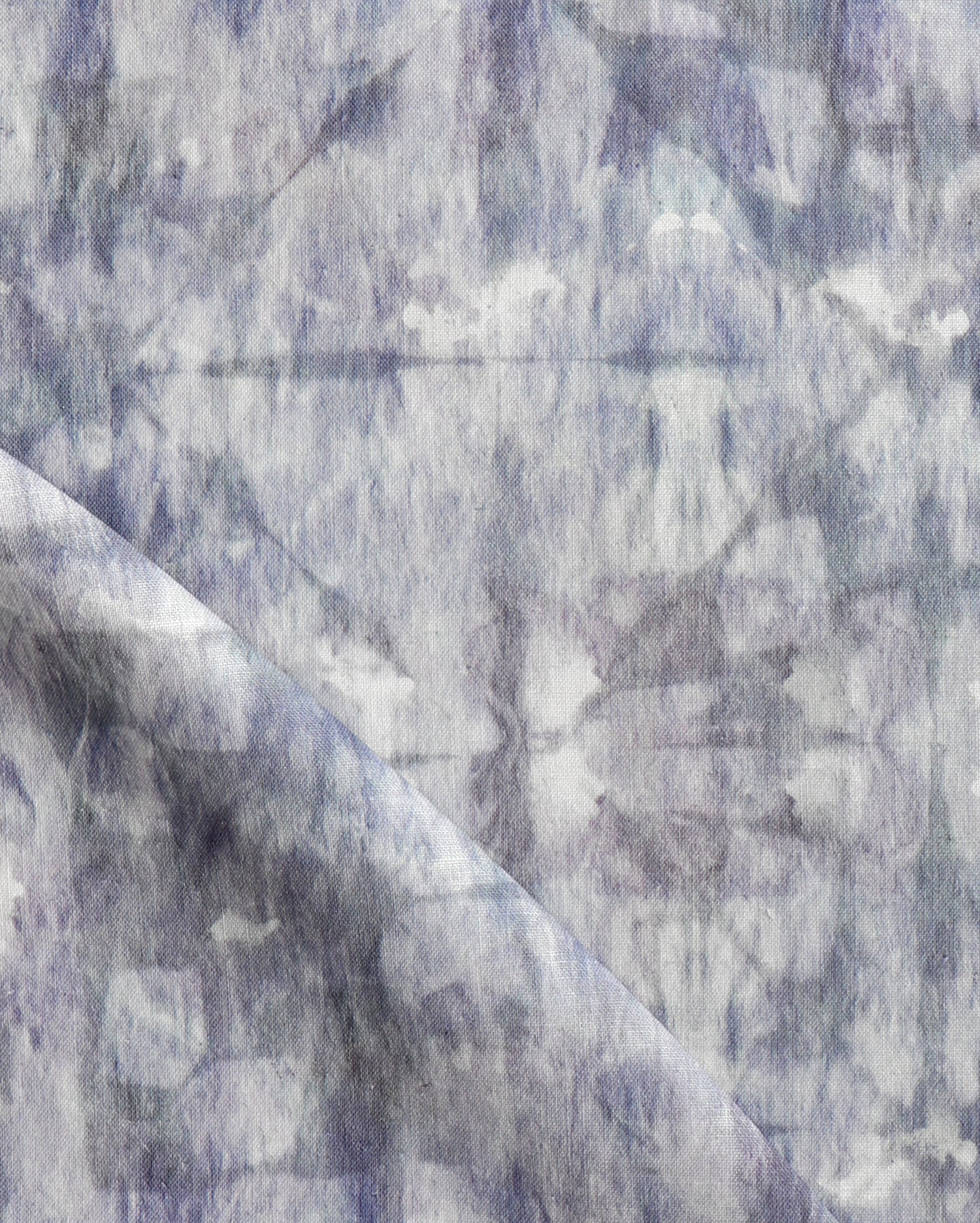 Detail of draped fabric in a watercolor dyed grid print in mottled shades of purple