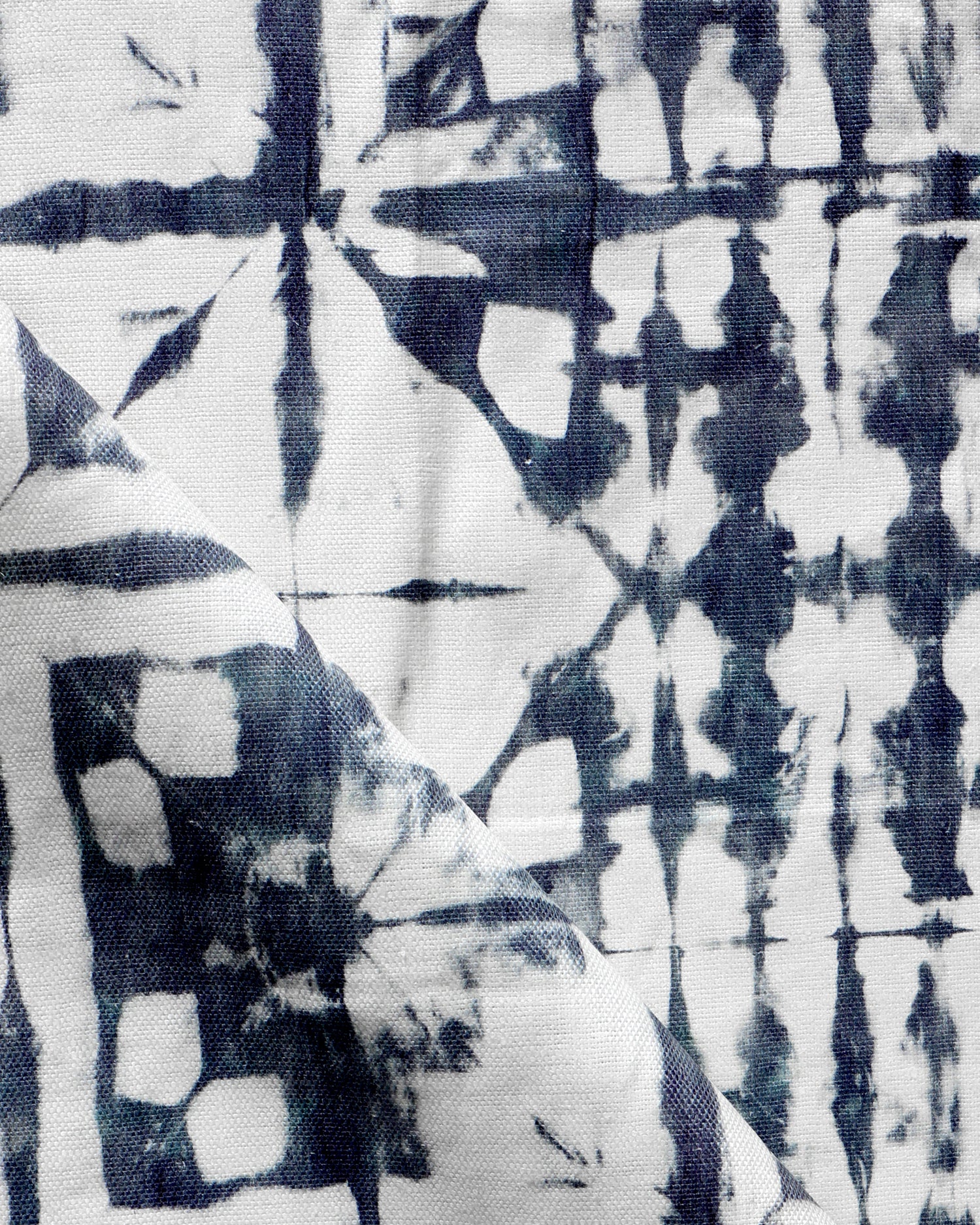 Detail of draped fabric in a watercolor dyed grid print in mottled white and navy.