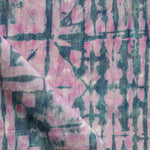 Detail of draped fabric in a watercolor dyed grid print in mottled pink and navy.