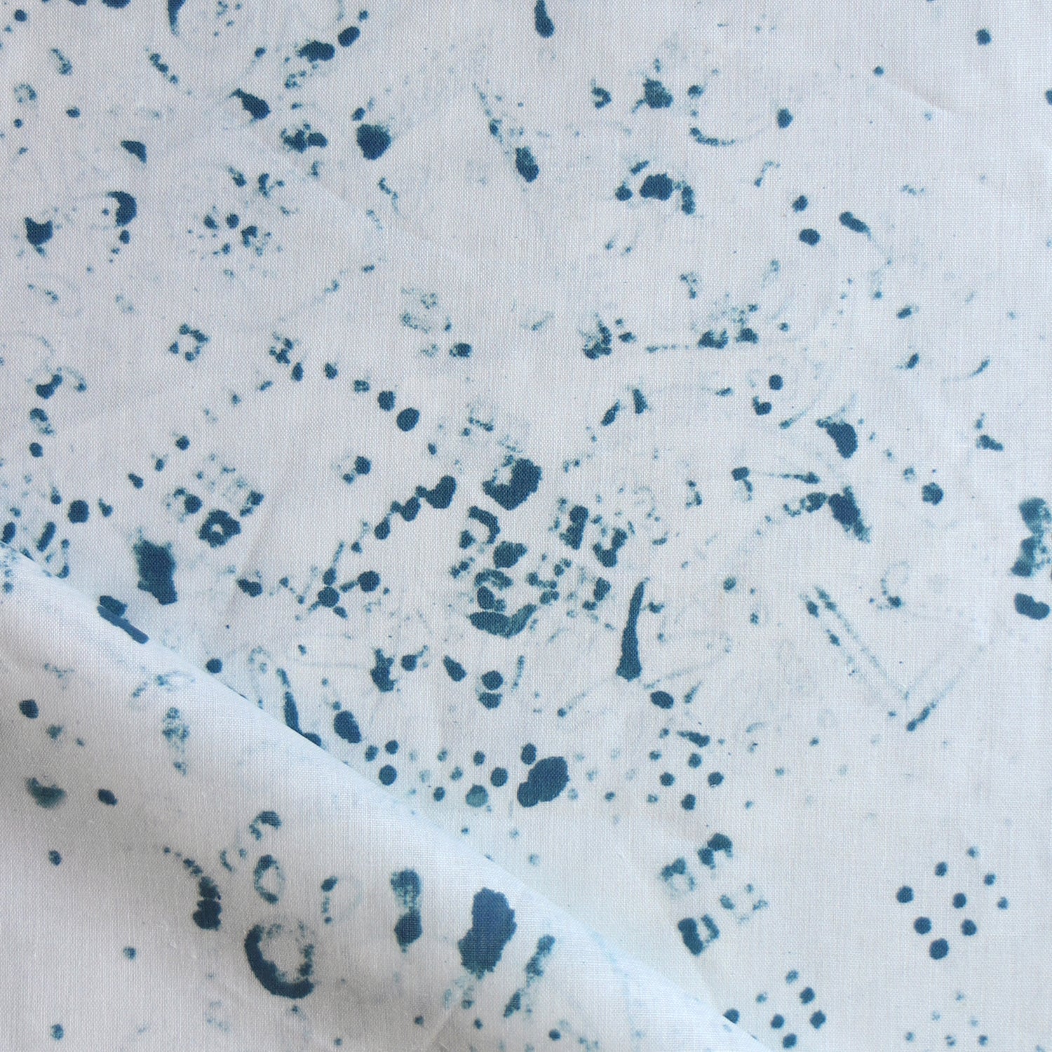 Detail of draped fabric in a painterly bandana print in navy on a white field.