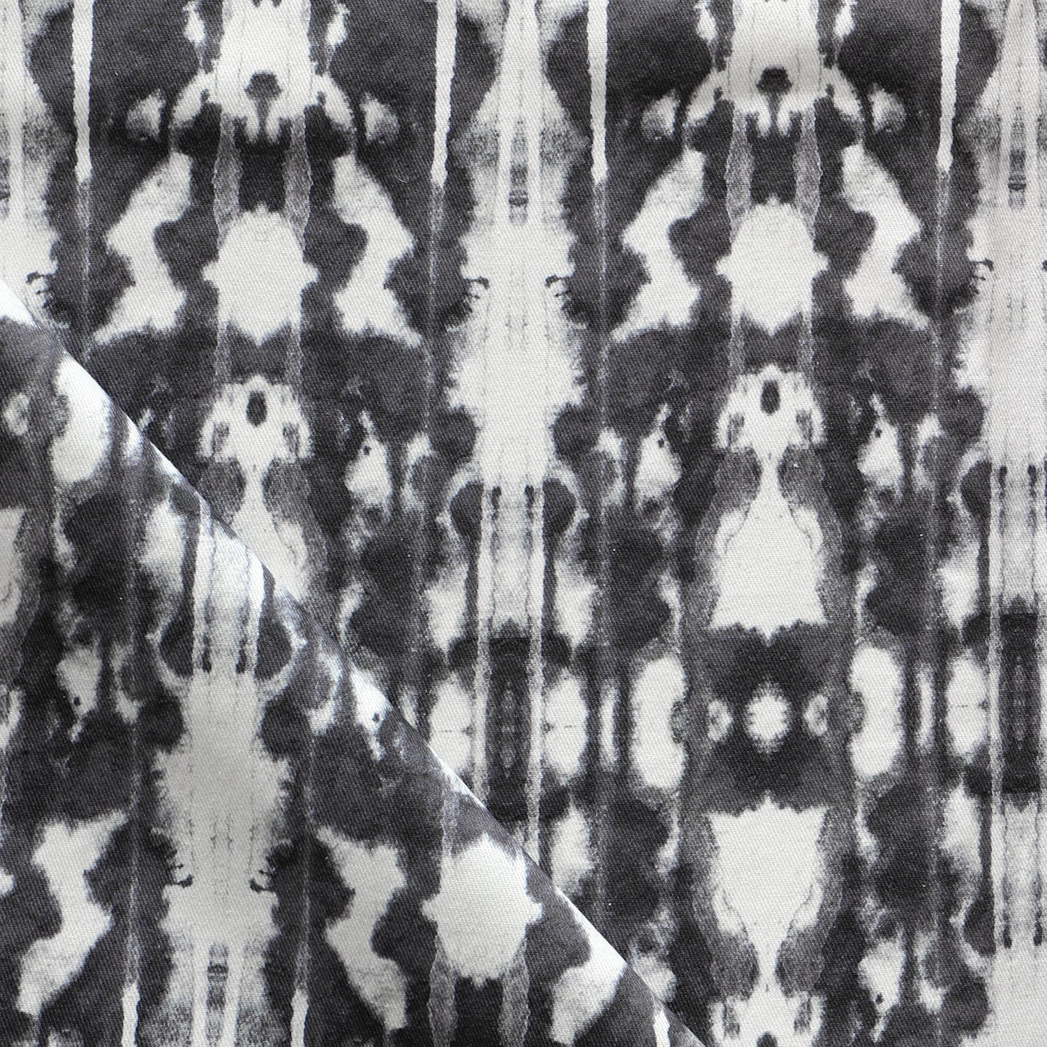 Detail of draped fabric in a painterly ikat print in black on a white field.