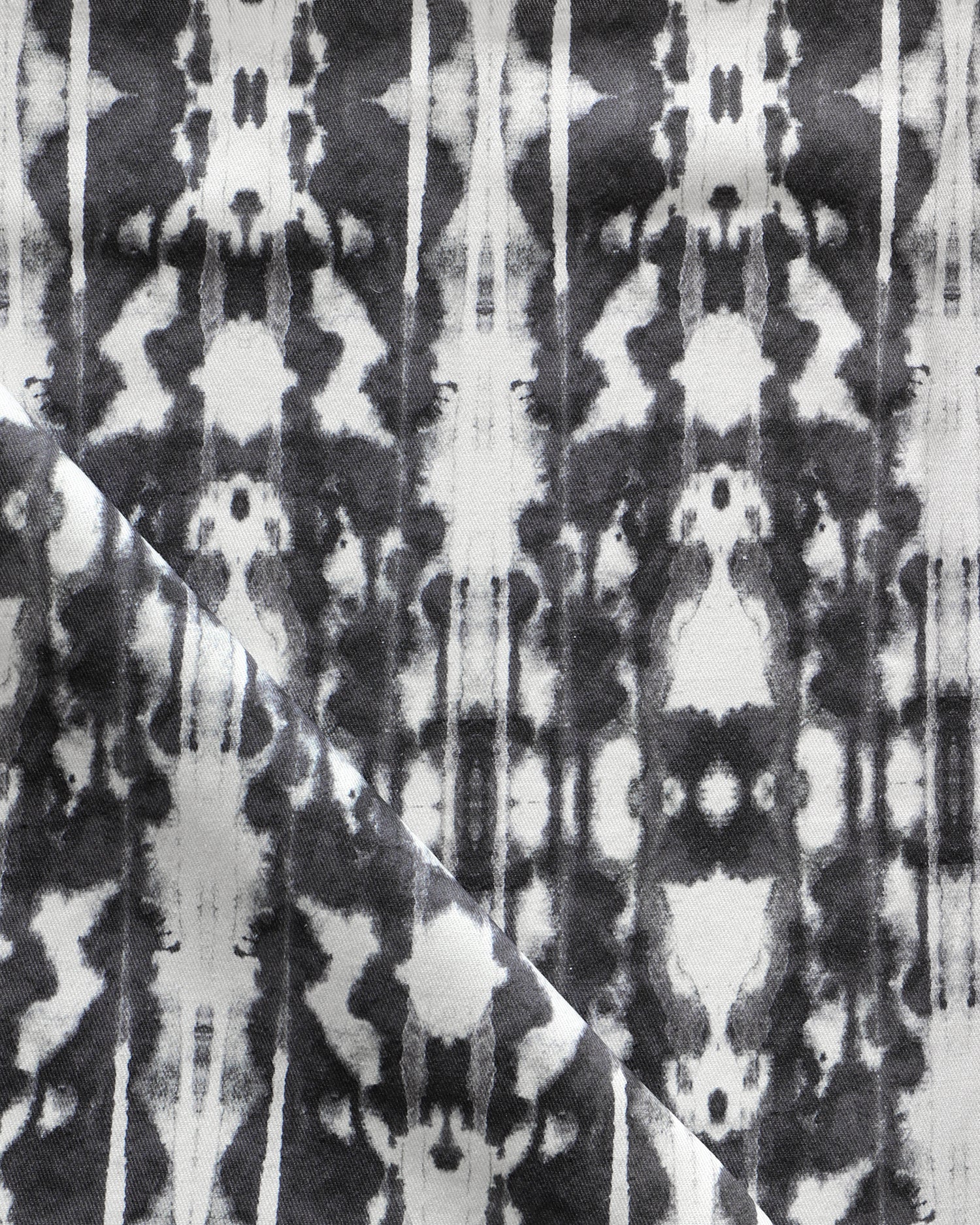 Detail of draped fabric in a painterly ikat print in black on a white field.