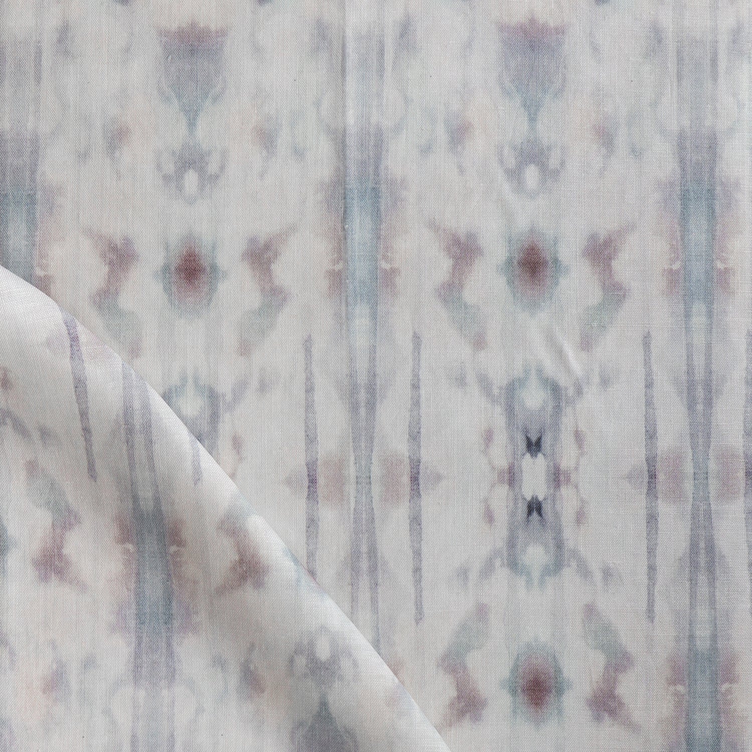 Detail of draped fabric in a painterly ikat print in turquoise, gray and tan.