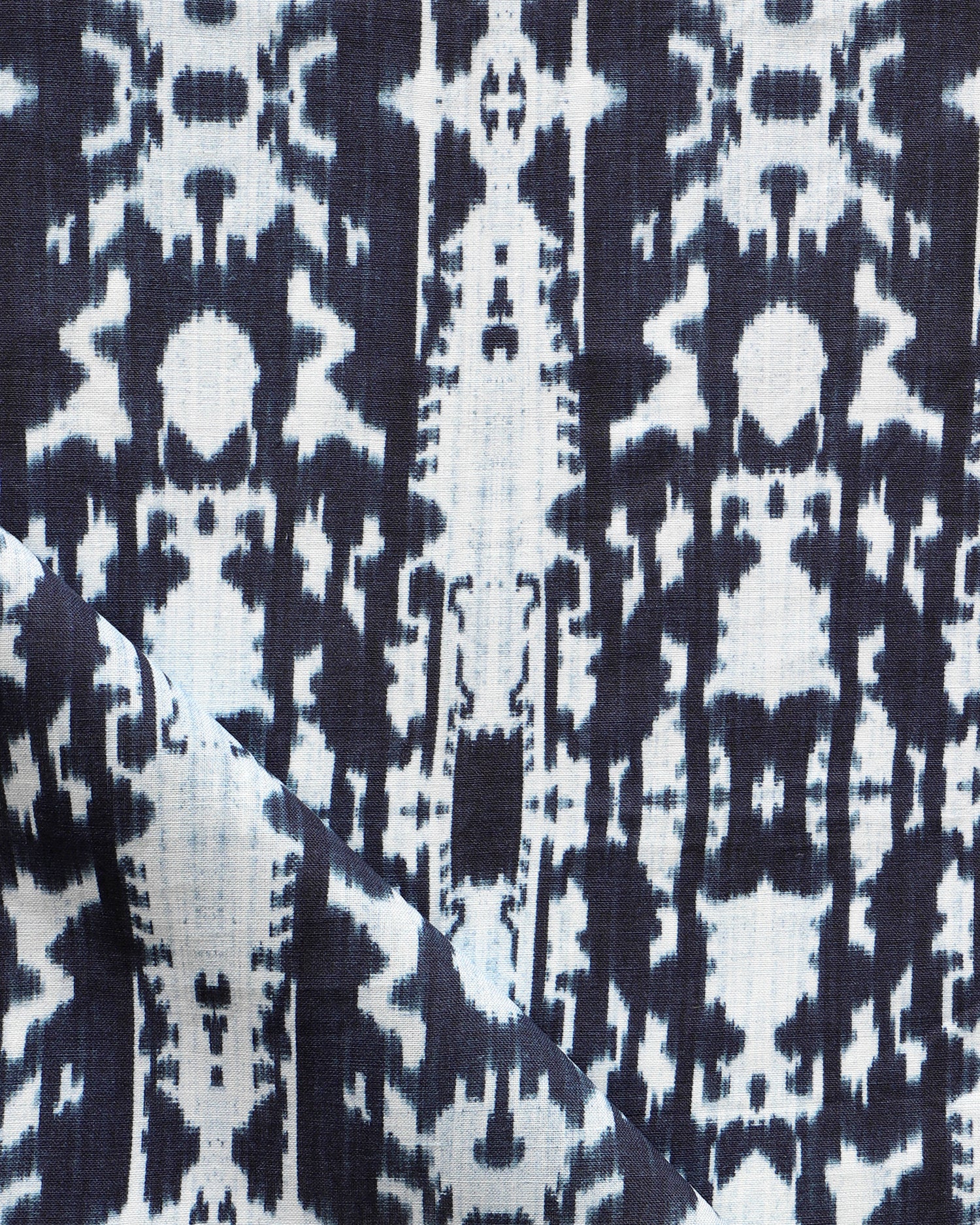Detail of draped fabric in a painterly ikat print in blue and white.