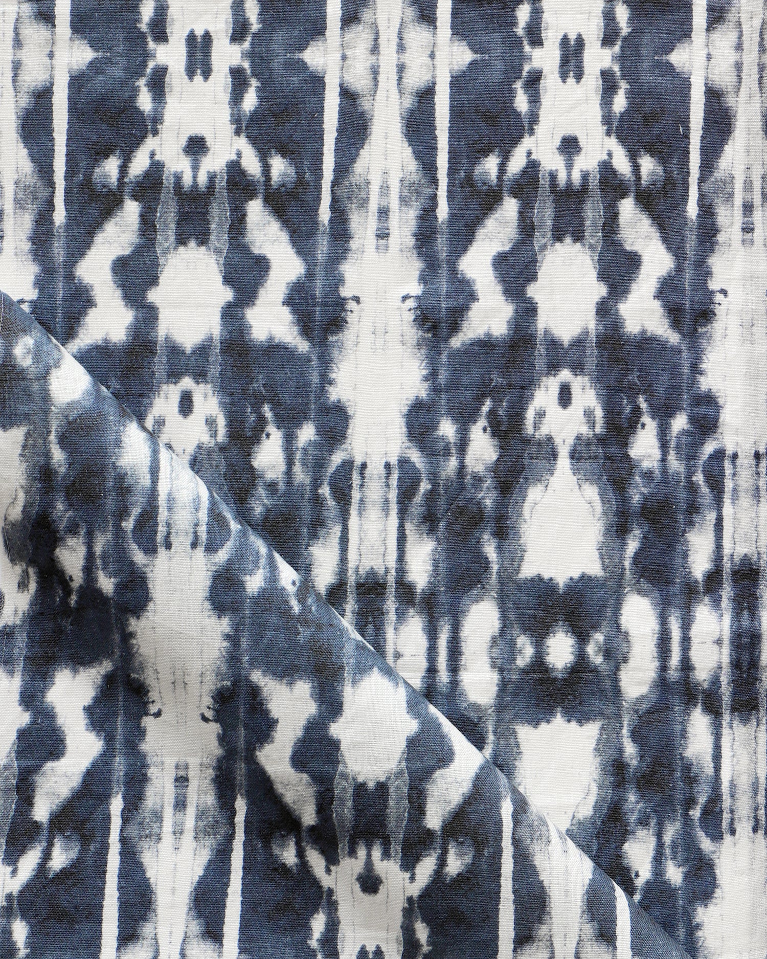 Detail of draped fabric in a painterly ikat print in navy and white.