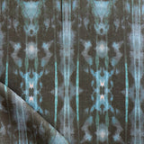 Detail of draped fabric in a painterly ikat print in turquoise and brown.