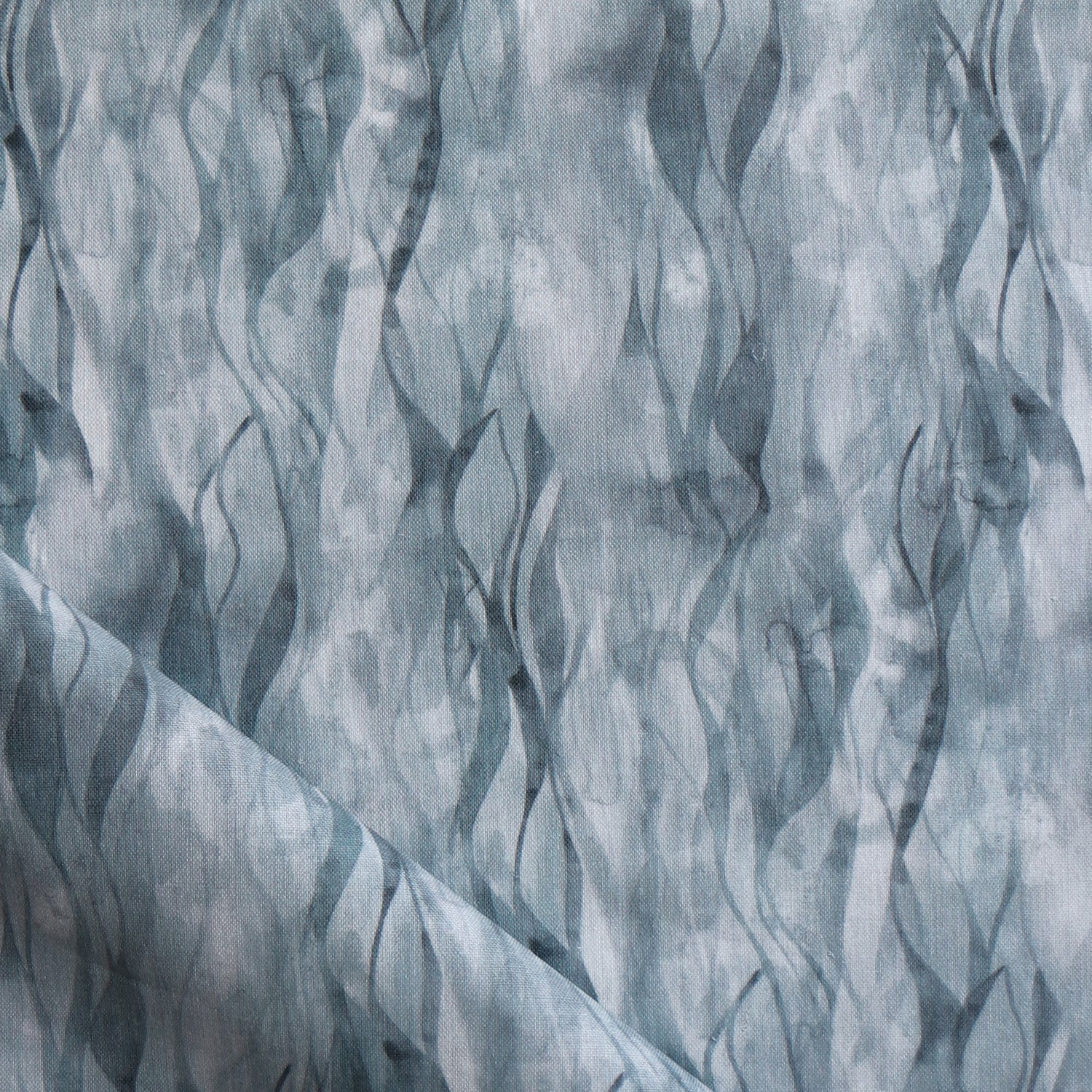 Draped fabric in a layered squiggle watercolor pattern in shades of steel blue. 