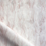 Draped fabric in a layered squiggle watercolor pattern in shades of pastel pink. 