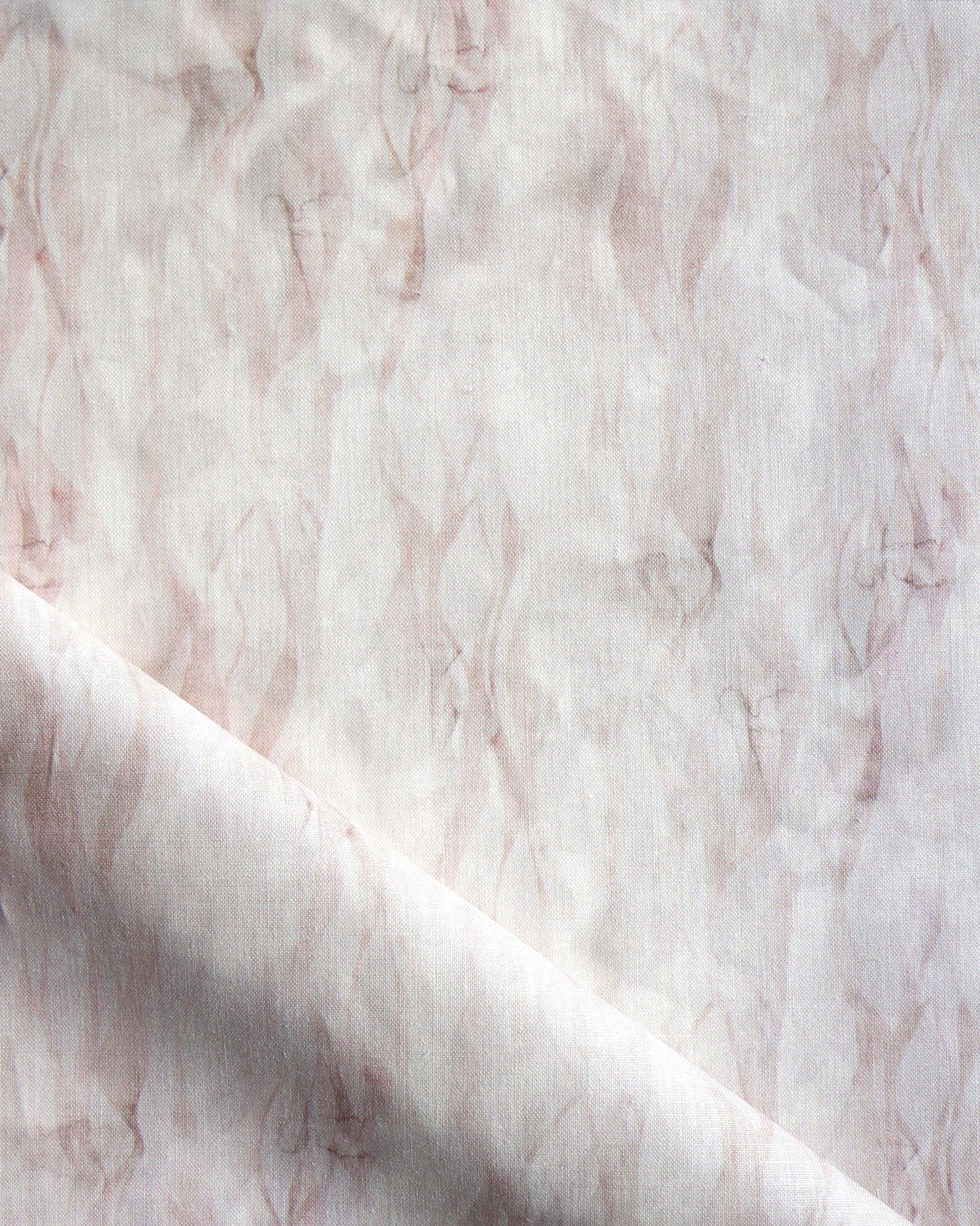 Draped fabric in a layered squiggle watercolor pattern in shades of pastel pink. 