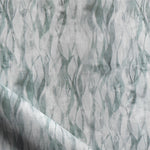 Draped fabric in a layered squiggle watercolor pattern in shades of muted teal. 