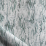 Draped fabric in a layered squiggle watercolor pattern in shades of muted teal. 