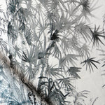 Detail of draped fabric in a painterly palm tree print in gray on a cream field.