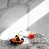 Dining room scene with a table cloth in a painterly palm tree print in gray on a cream field.
