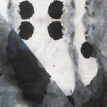 Detail of draped fabric in a watercolor ink blot print in shades of charcoal and gray on a white field.