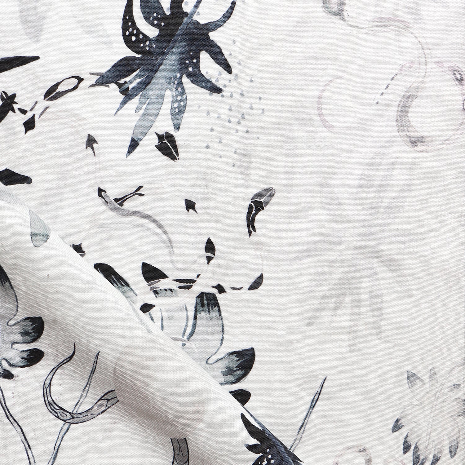 Detail of draped fabric in a playful leaf and snake print in gray and navy on a cream field.