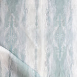 Detail of draped fabric in a watercolor textural print in shades of gray and blue-gray.