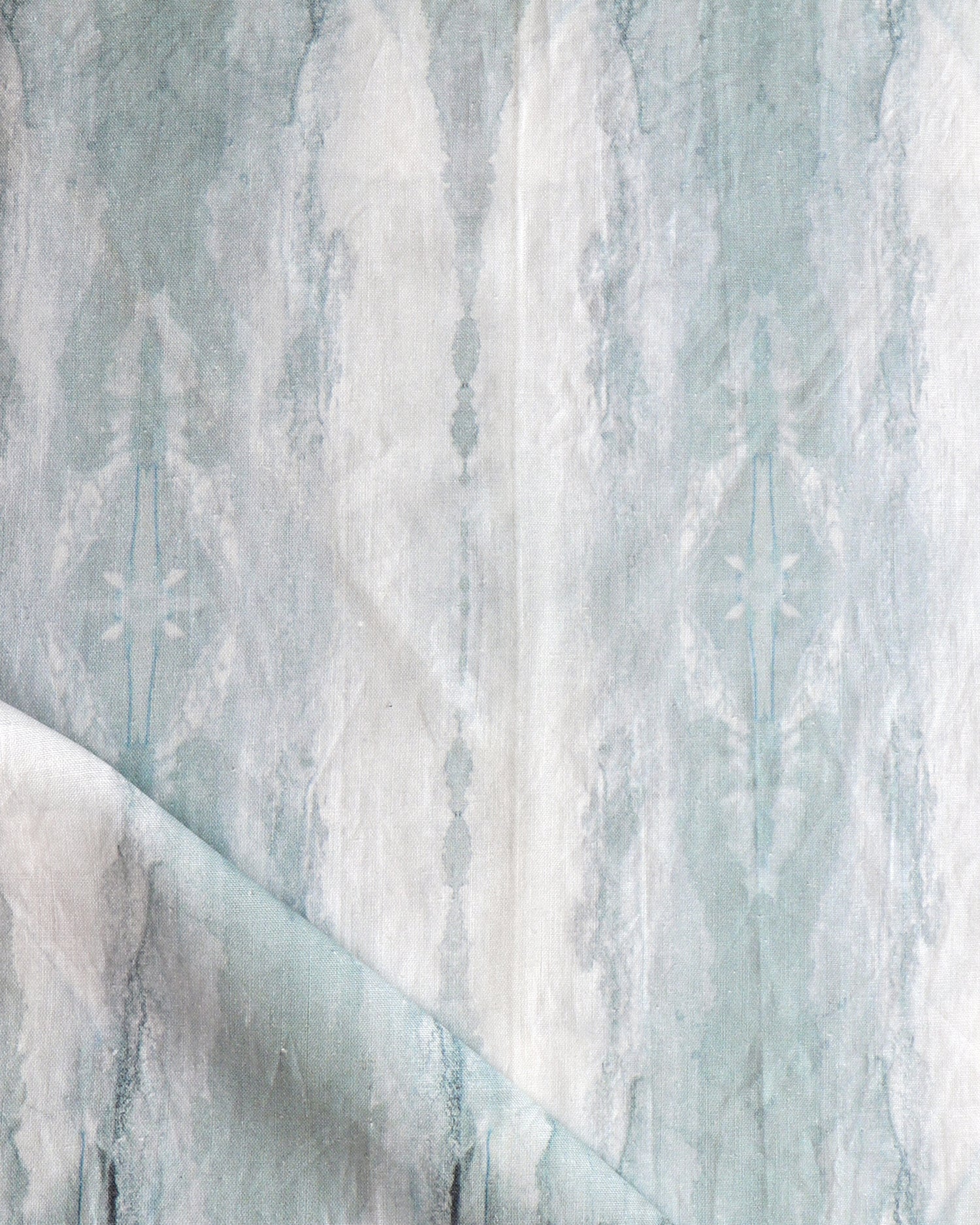 Detail of draped fabric in a watercolor textural print in shades of gray and blue-gray.