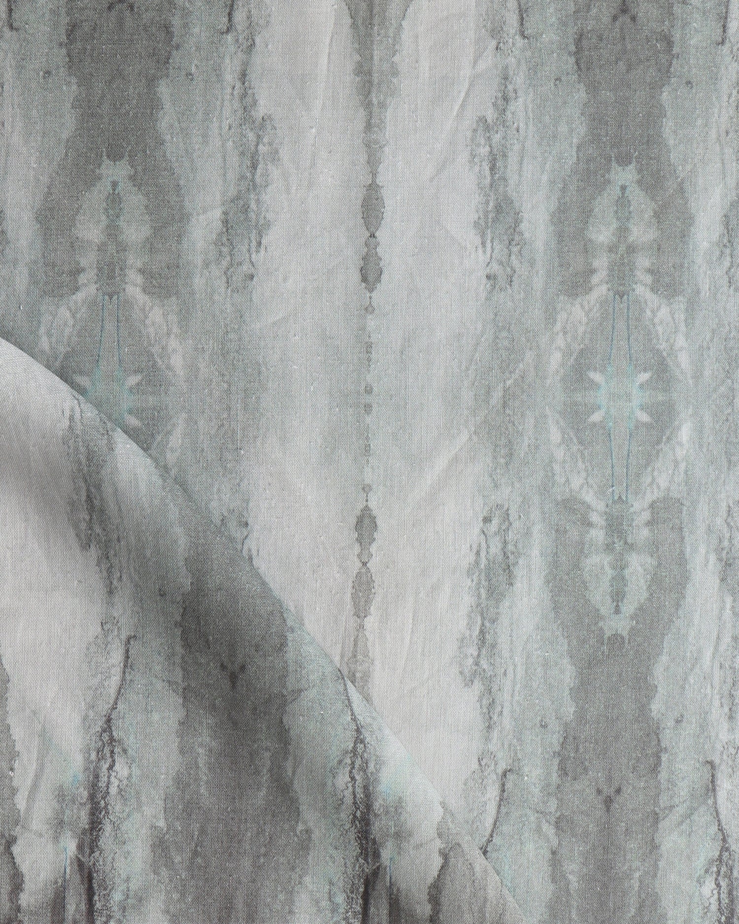 Detail of draped fabric in a watercolor textural print in shades of gray.