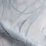 Draped fabric in abstract floral bushstroke design in soft slate blue. 