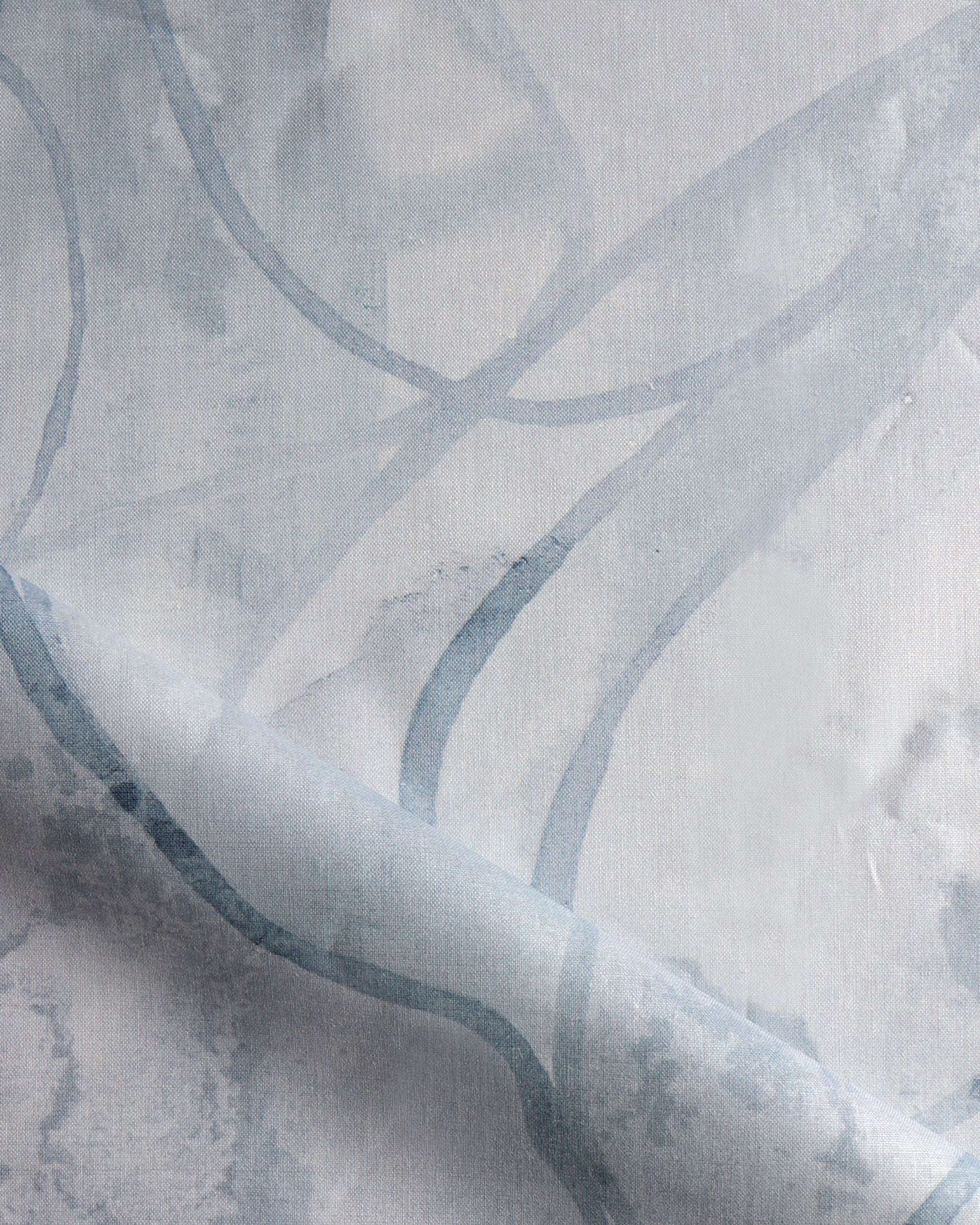 Draped fabric in abstract floral bushstroke design in soft slate blue. 