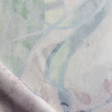 Draped fabric in abstract floral bushstroke design in sage green, lilac and blue. 