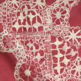 White lace pattern on a red fabric background