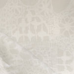 Close-up of a watercolor lace design in soft beige. 