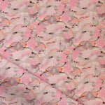 Draped fabric in an undulating abstract watercolor motif in pink, orange and grey. 