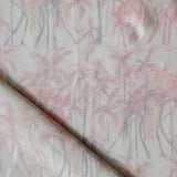 Detail of draped fabric in a painterly palm tree stripe print in shades of pink and gray on a white field.