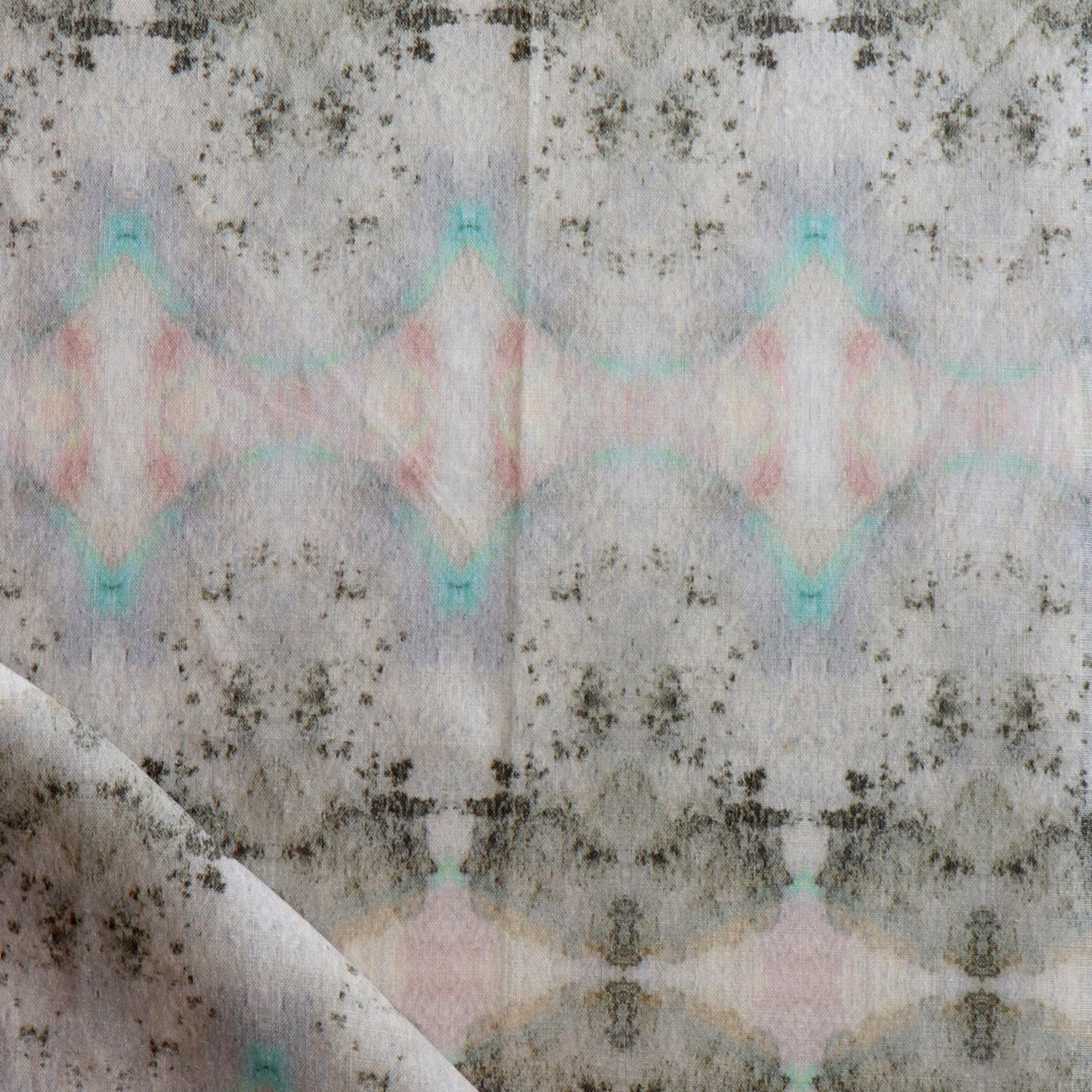 Detail of draped fabric in a watercolor ink blot pattern in shades of tan, turquoise and pink.
