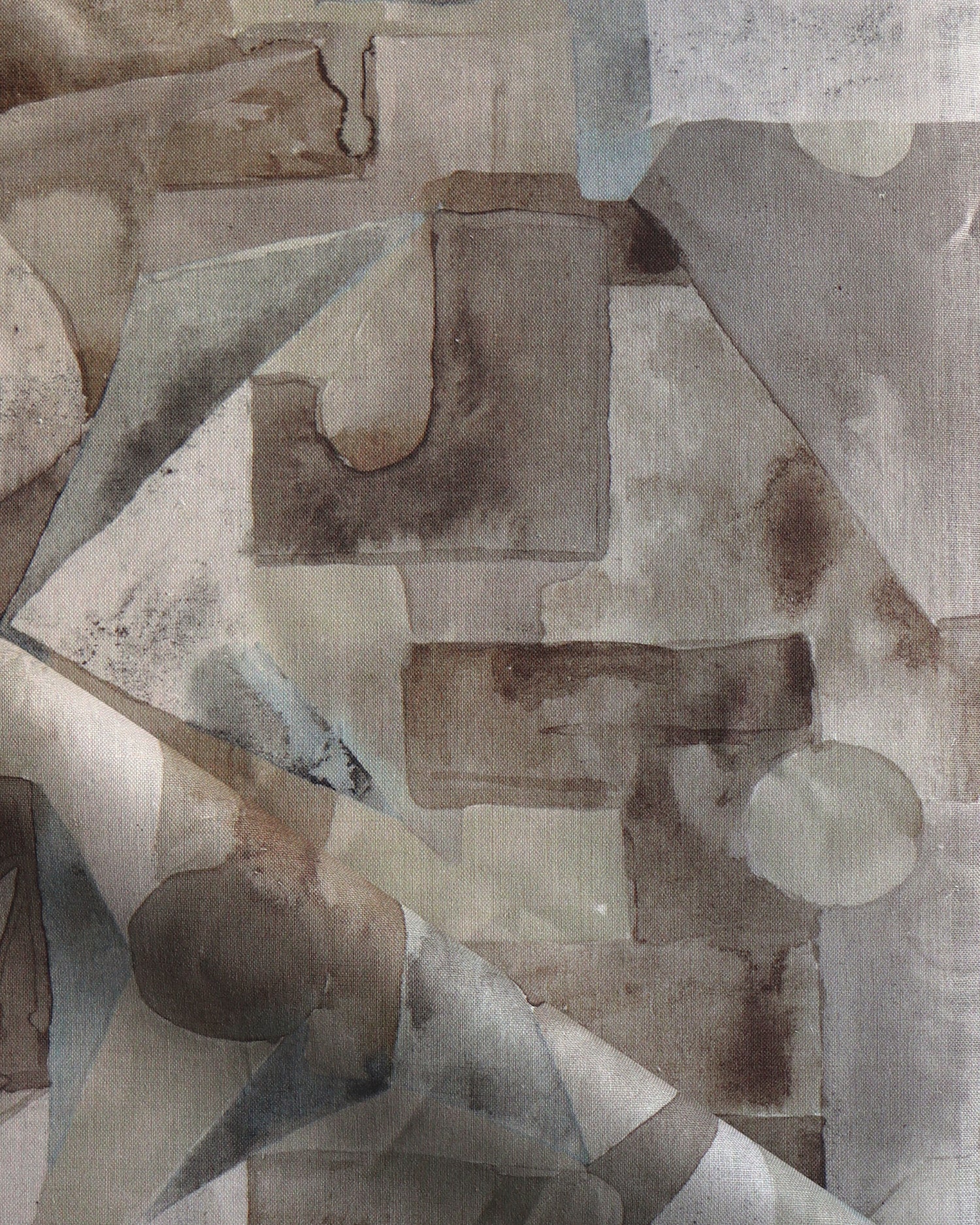 Draped fabric in a geometric puzzle piece watercolor pattern in brown and charcoal. 
