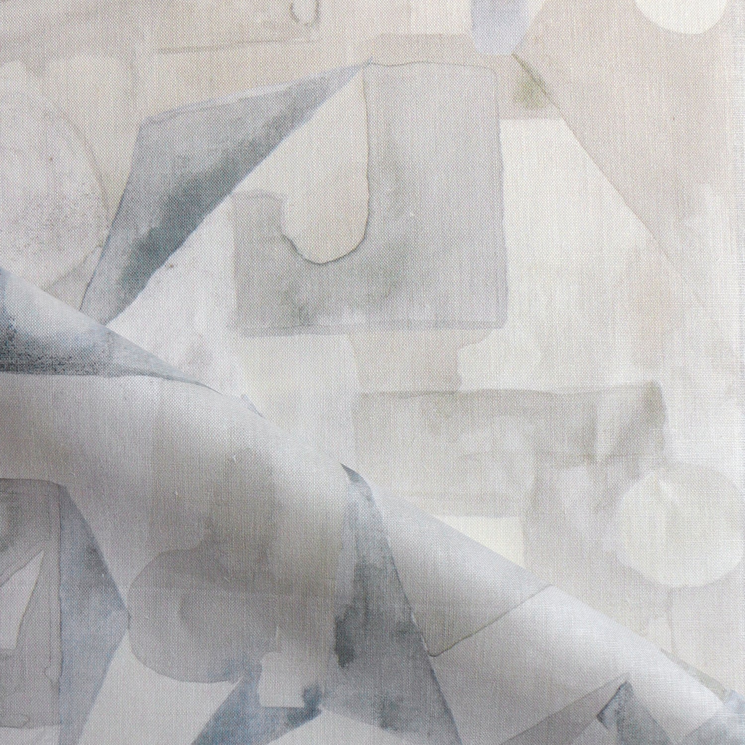 Draped fabric in a geometric puzzle piece watercolor pattern in beige and grey. 