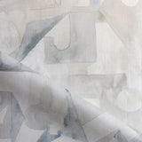 Draped fabric in a geometric puzzle piece watercolor pattern in beige and grey. 