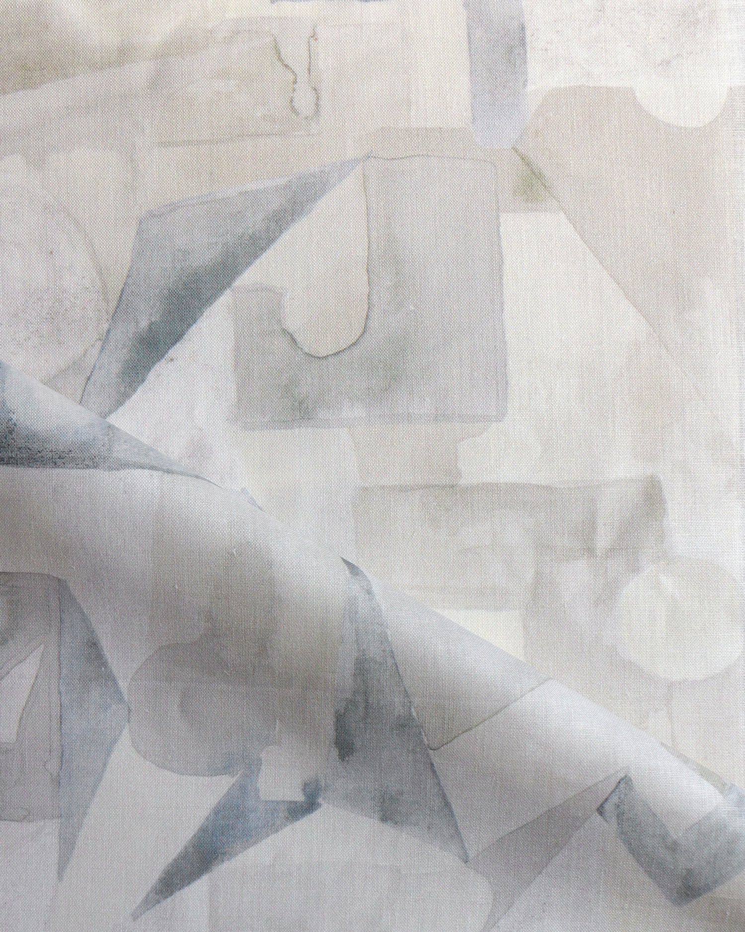 Draped fabric in a geometric puzzle piece watercolor pattern in beige and grey. 