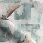 Draped fabric in a geometric puzzle piece watercolor pattern in sage green, grey and brown. 
