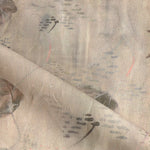 Draped fabric in an watercolor oceanic fish pattern in warm tan. 