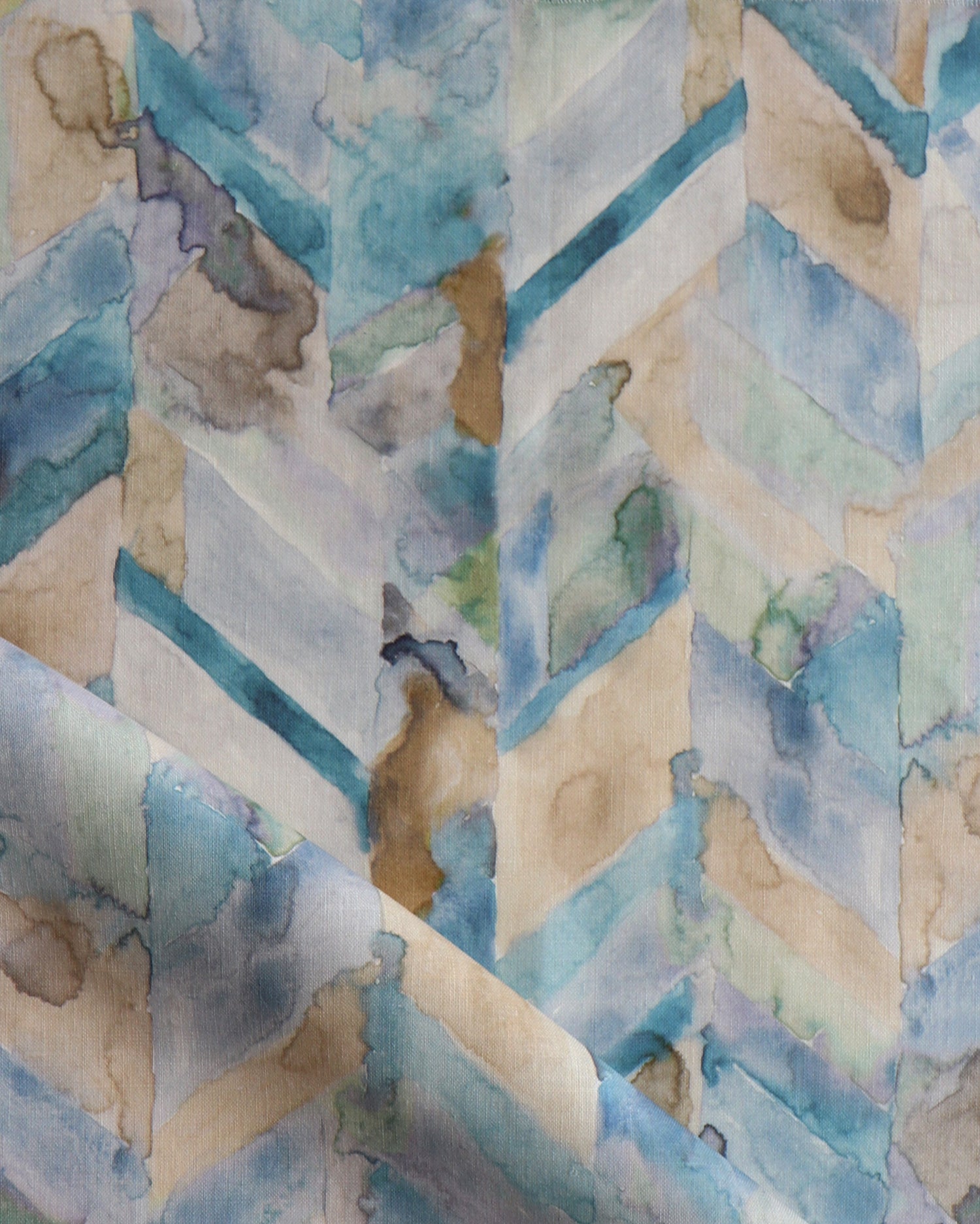 Detail of draped fabric in a painterly herringbone print in shades of blue, green and brown.