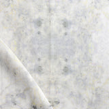 Detail of draped fabric in a watercolor textural print in shades of cream, gray and tan.