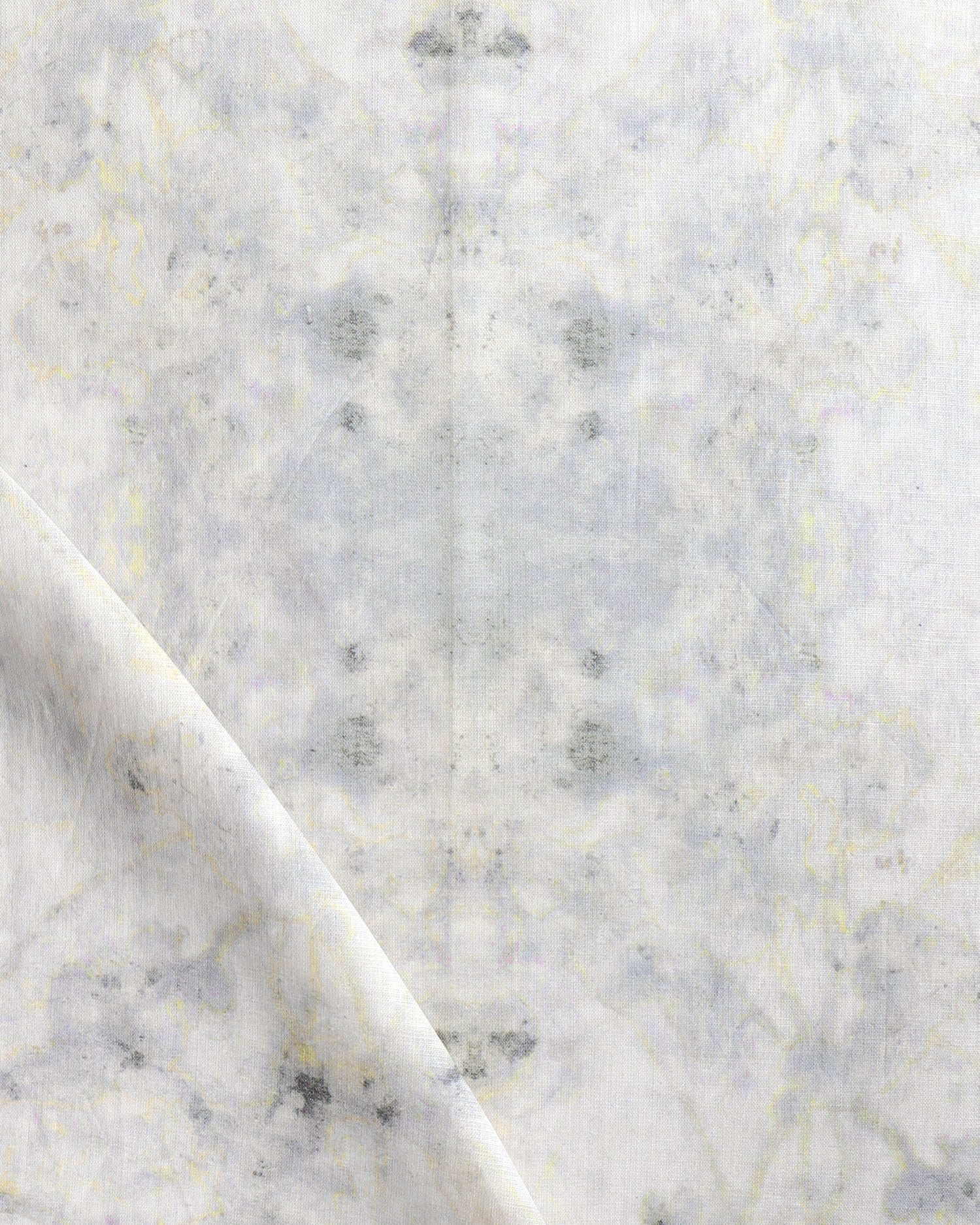 Detail of draped fabric in a watercolor textural print in shades of cream, gray and tan.
