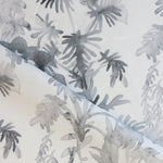 Draped fabric in an watercolor palm frond pattern in shades of grey.