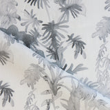 Draped fabric in an watercolor palm frond pattern in shades of grey.