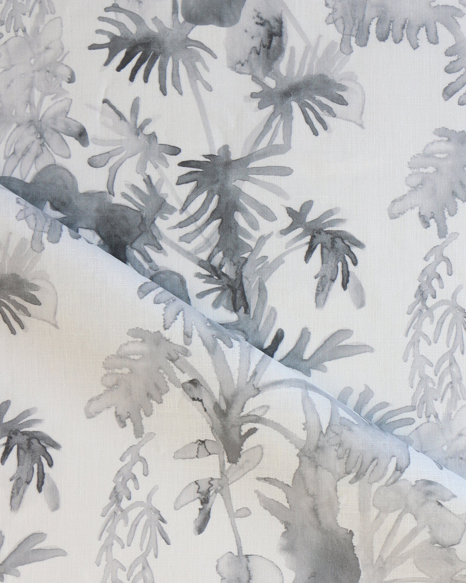 Draped fabric in an watercolor palm frond pattern in shades of grey.